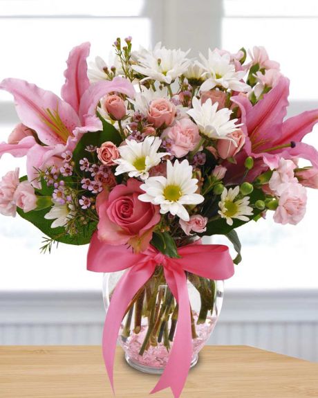 Pink Sonnet-Lovely mini pink carnations, pink spray roses, pink roses, stargazer lilies, white  daisy poms, waxflower, lemon leaf, arranged in a ginge jar vase wit a pink ribbon-floral arrangements