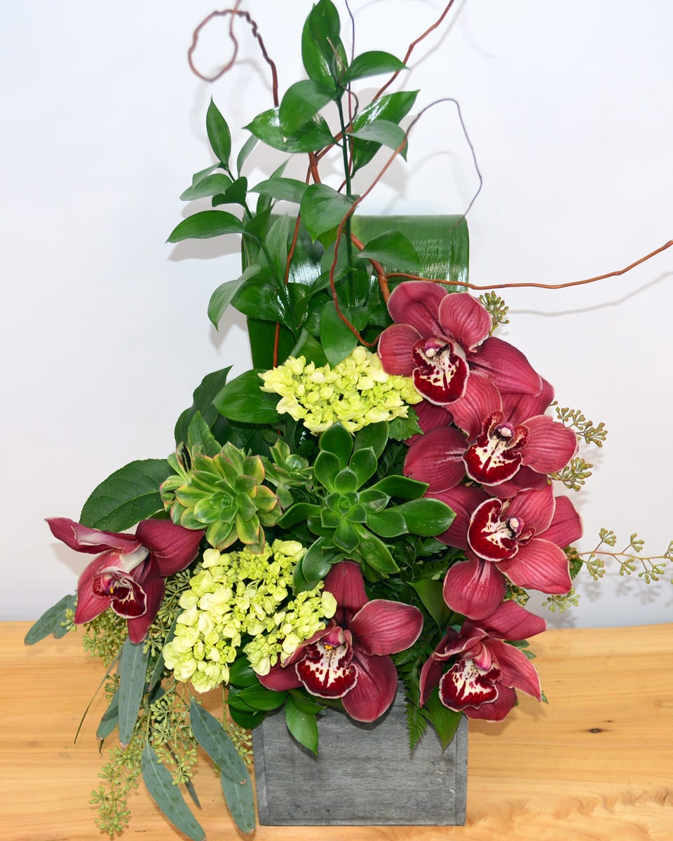 Islands Deluxe  Islands-Luscious, exotic cymbidium orchids and tropical greens are elegantly arranged in a rustic wood box.
DELIVERY: Every order is hand-delivered direct to the recipient. These items will be delivered by us locally, or a qualified retail local florist.
