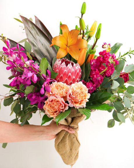Wildflower Fields-Seasonal and tropical flowers and foliage comprise this hand bouquet-Same day Flower Delivery 