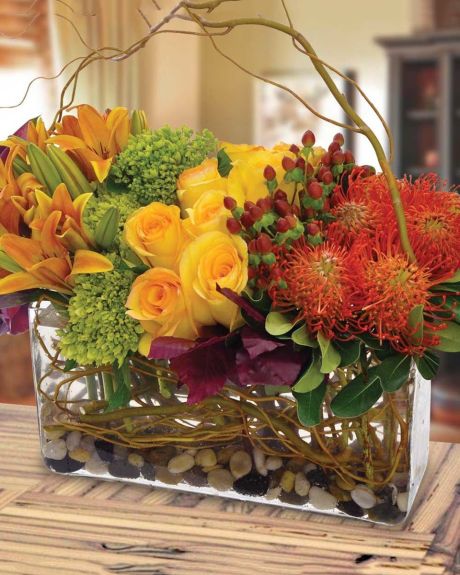 BRANCHING OUT-A unique and luxurious arrangment of fall colored flowers and a stylish branch, all set in a glass vase.-FALL ARRANGEMENT